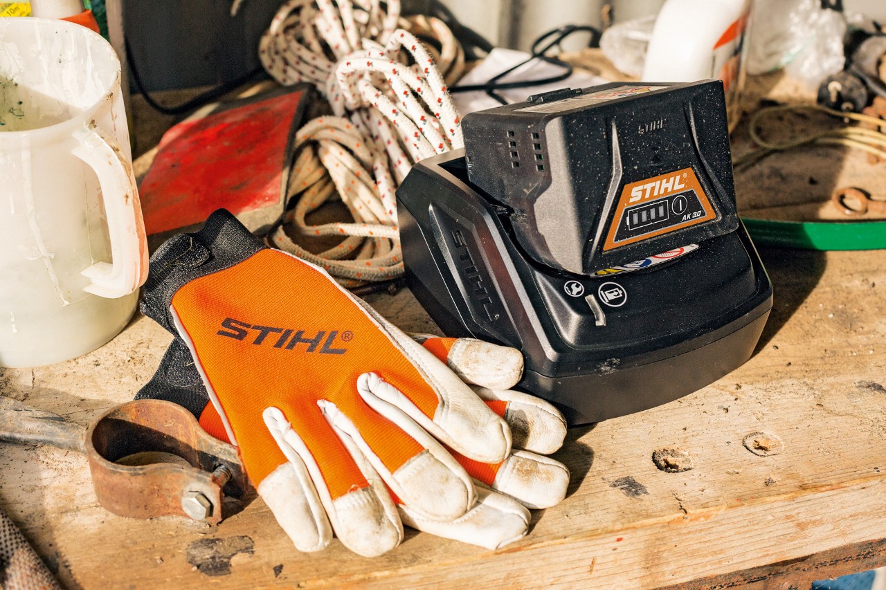 Battery and gloves lying on a work surface