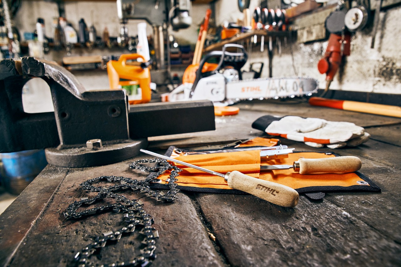 Tool and saw chain set out on a workbench for tensioning on the chainsaw