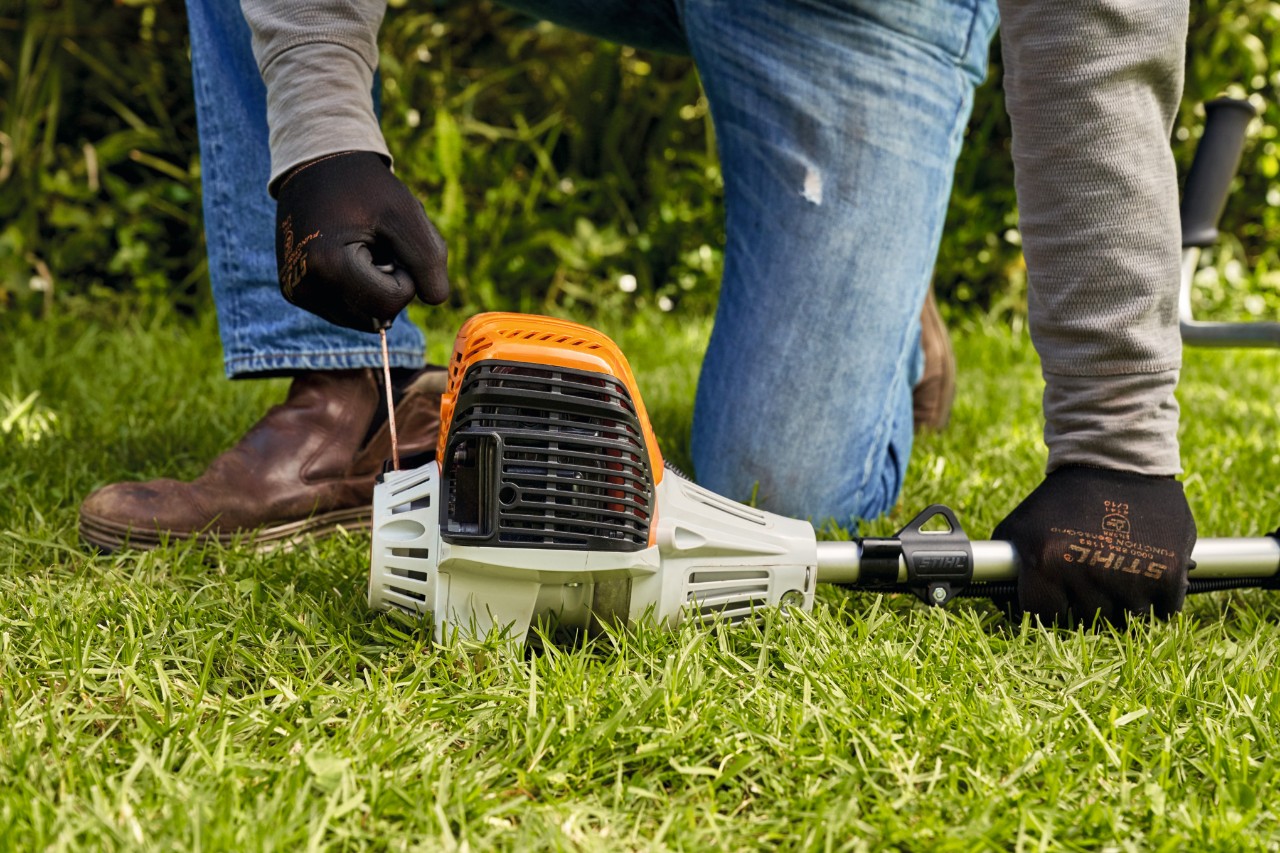 A man pulling the starter cord of a STIHL FS 91 petrol brushcutter 