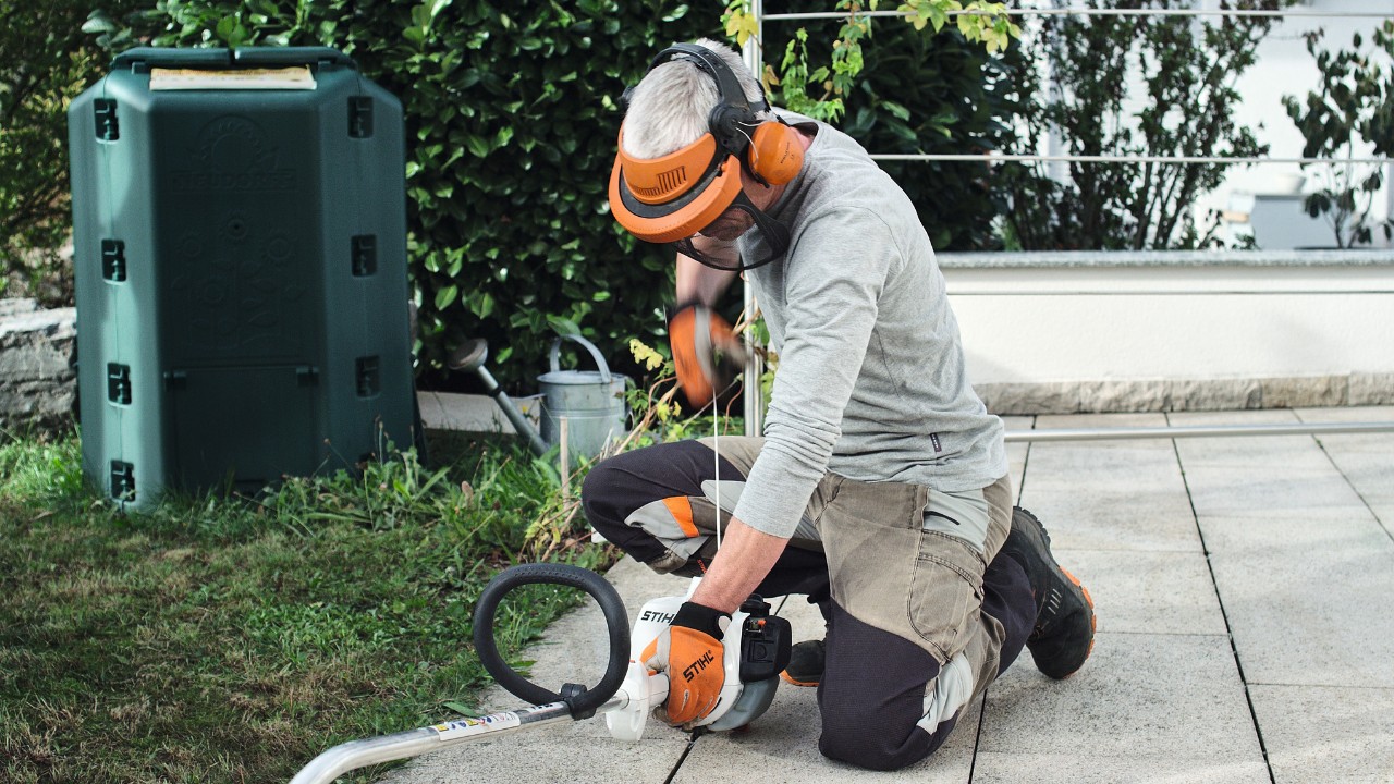 Person wearing protective clothing pulling on the starter cord of the STIHL FS 38 petrol brushcutter