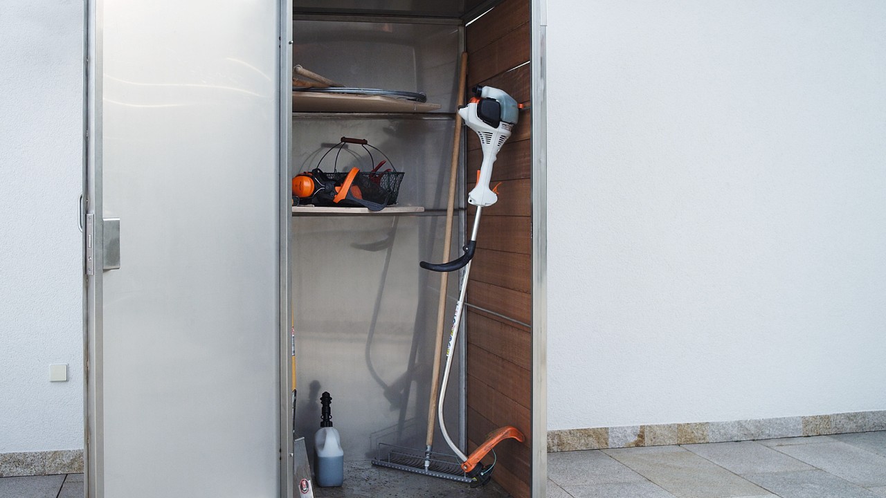 After being switched off, a STIHL FS 38 petrol brushcutter is stored in a cabinet