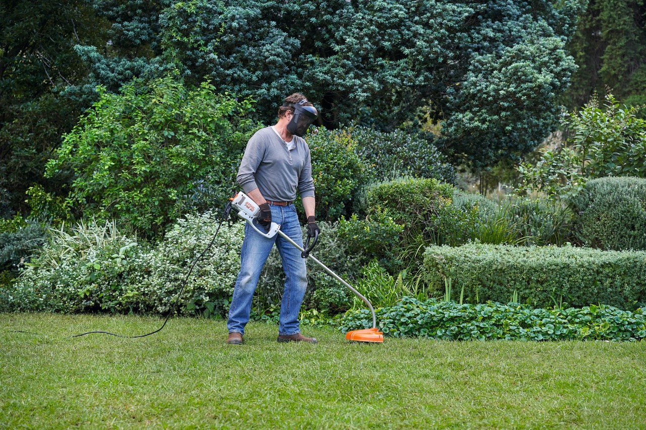 A man with a STIHL FSE 60 electric brushcutter taking a secure stance on his feet