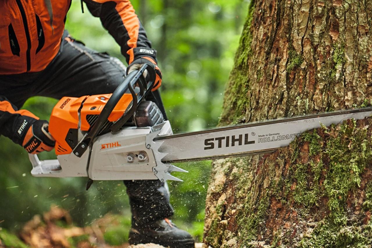 A person sawing a tree with a STIHL MS 881 petrol chainsaw with a nose bar