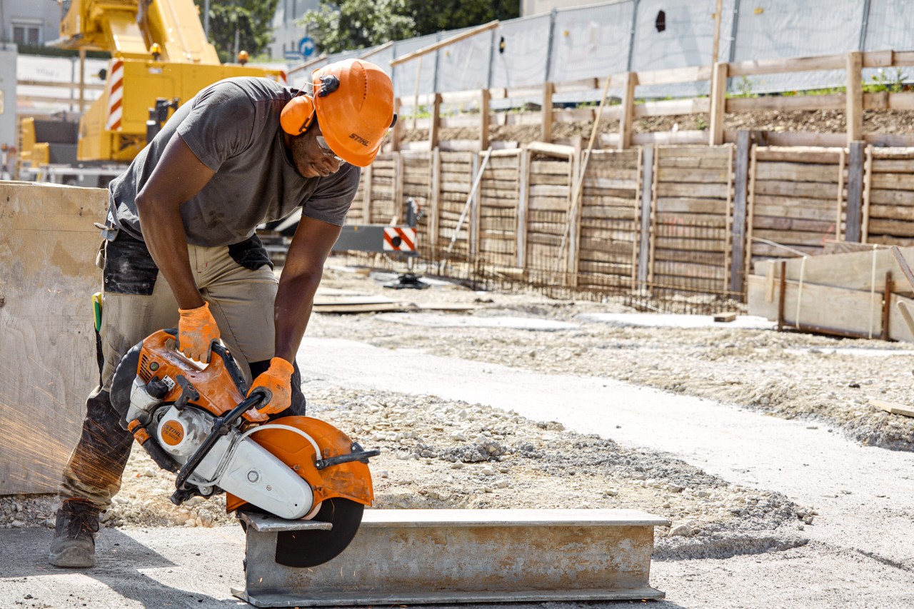 A man using a STIHL TS 500i cut-off machine with an abrasive cutting wheel on a construction site