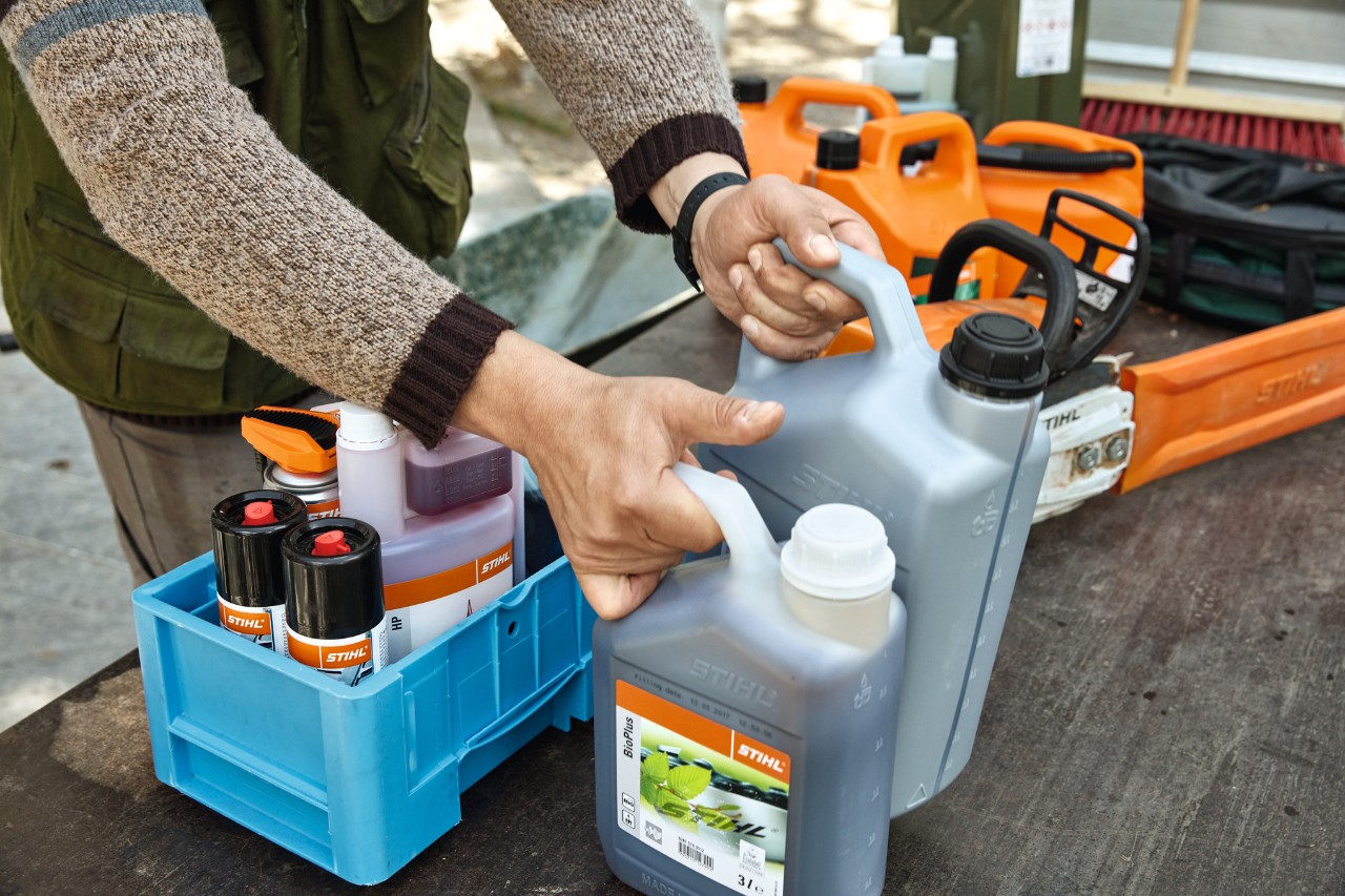 A person tidying up STIHL fuels and lubricants in crates for transport 